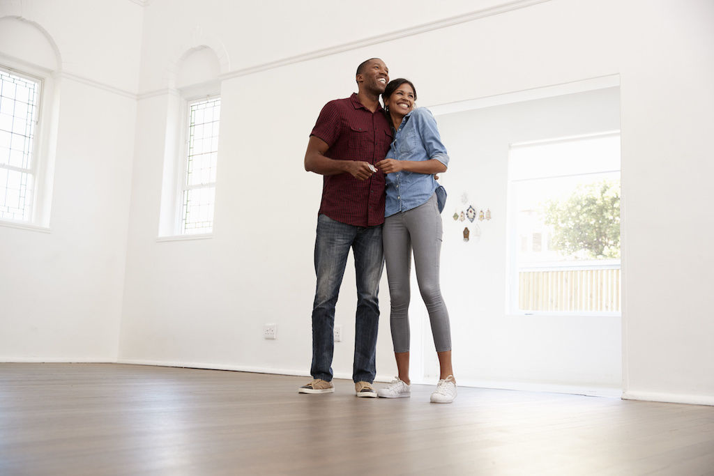 Couple standing in empty apartment